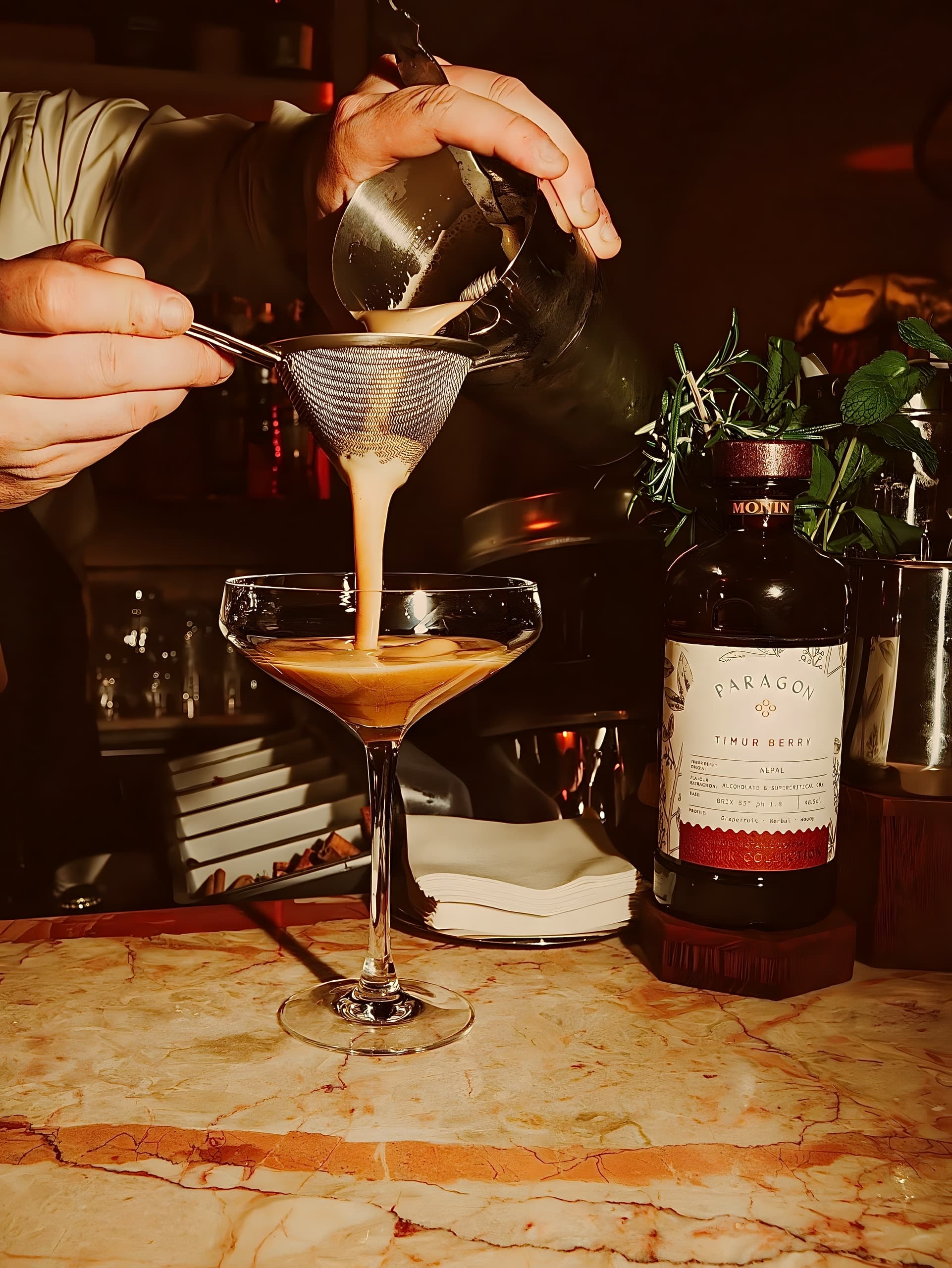 Le barman au geste précis, cocktail passé au tamis