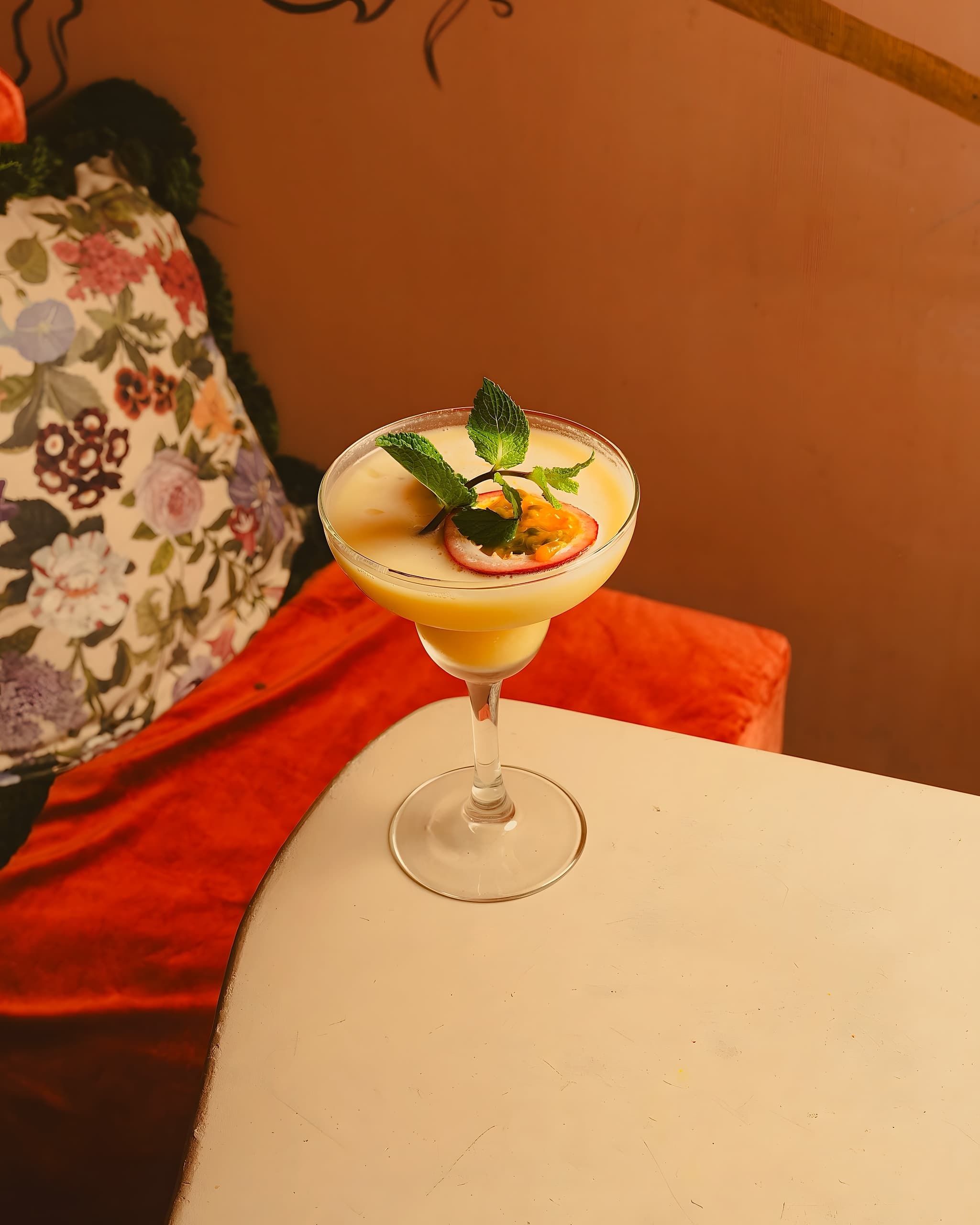 Cocktail au fruit de la passion devant le mur terracotta